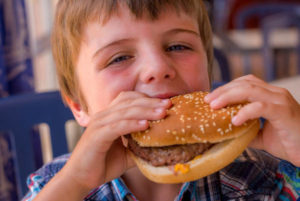 ハンバーガーを食べる子供